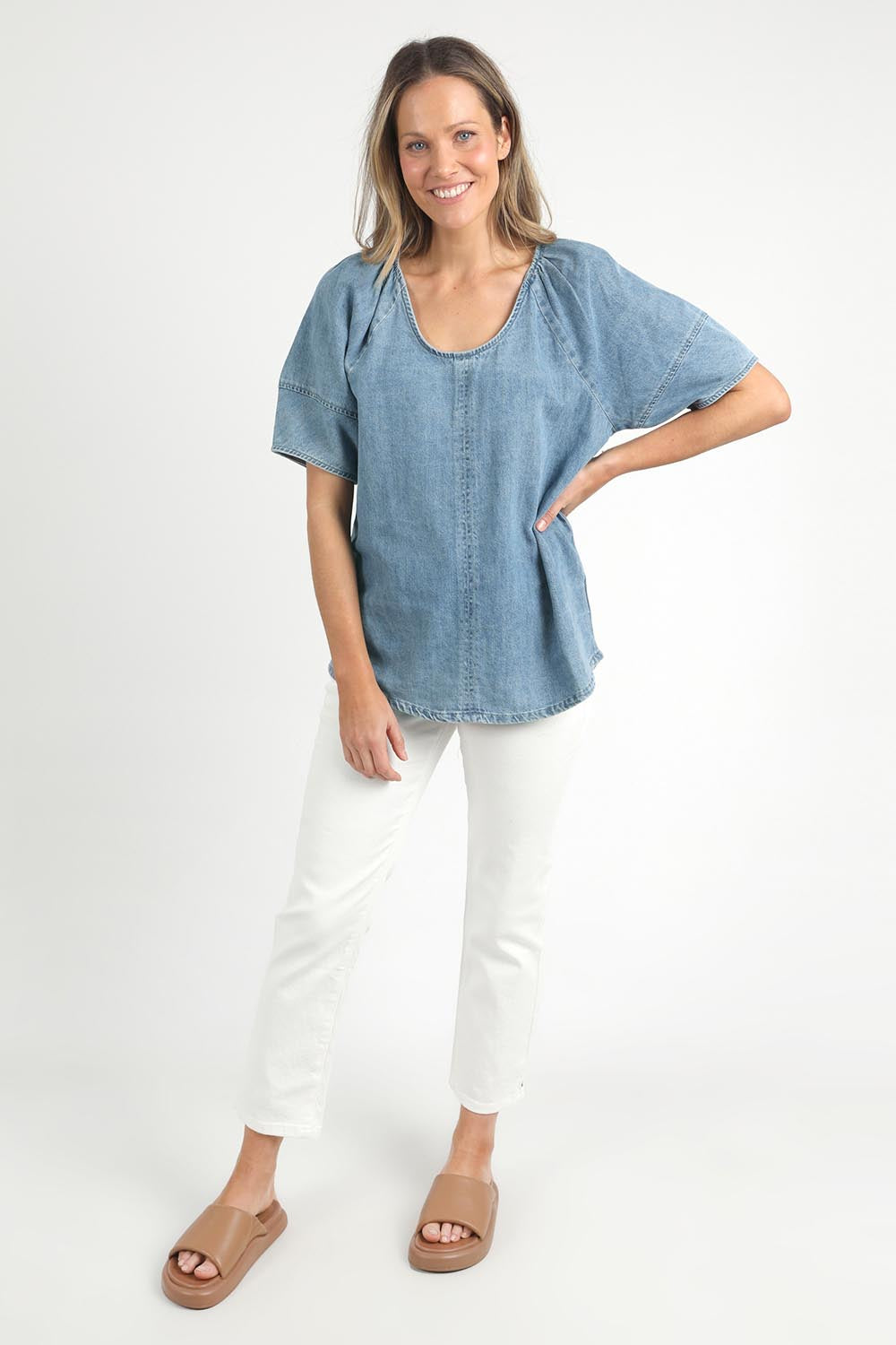 A model wearing the Brea Top in colour Bluewash (Blue), from the front, showing the whole outfit