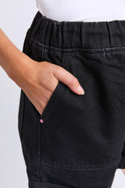 Model Genericm wearing size sample of the Fundamental Emma Relaxed Denim Short – Black in colour Black, from an angle