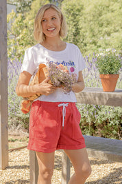 A model wearing the Emma Relaxed DenimShort in colour Poppy (Red), from the front, showing the whole outfit
