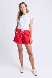 A model wearing the Emma Relaxed DenimShort in colour Poppy (Red), from the front, showing the whole outfit