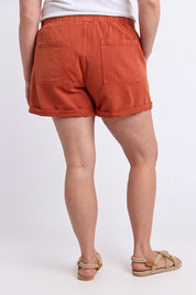 Model Genericm wearing size sample of the Fundamental Emma Relaxed Denim Short – Earthbrown in colour Earthbrown, from the back