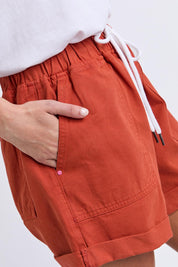 Model Genericm wearing size sample of the Fundamental Emma Relaxed Denim Short – Earthbrown in colour Earthbrown, in a cropped view