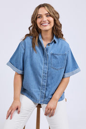 A model wearing the Annika Ss Denim Shirt in colour Midblue (Blue), from the front, cropped image