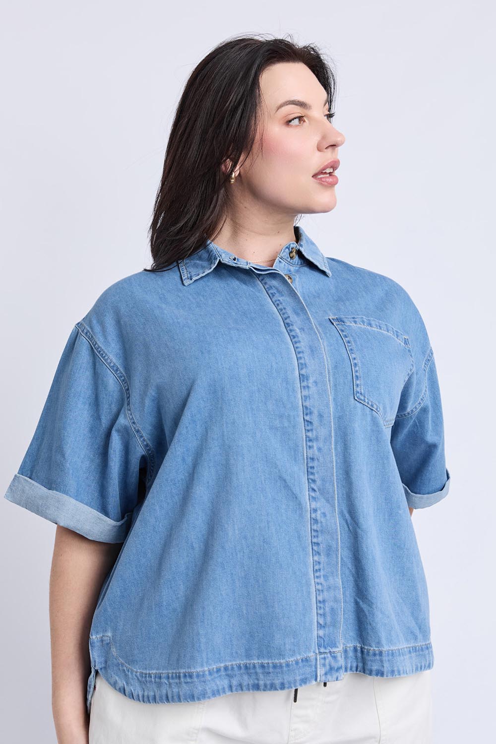 A model wearing the Annika Ss Denim Shirt in colour Midblue (Blue), from the front, cropped image