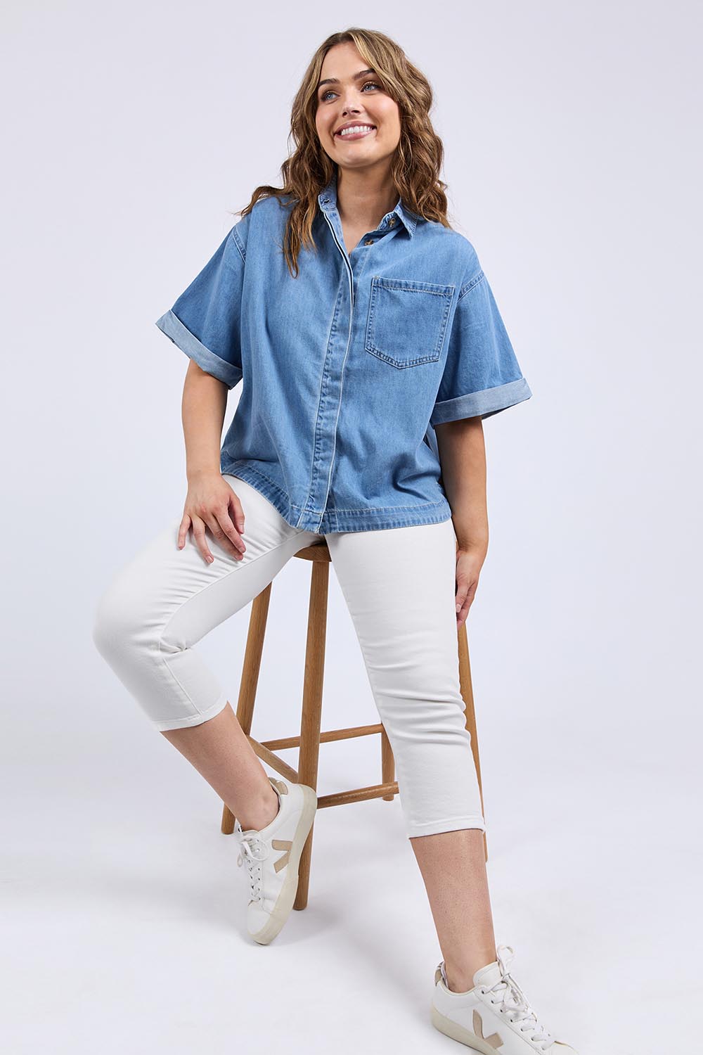 A model wearing the Annika Ss Denim Shirt in colour Midblue (Blue), from the front, showing the whole outfit