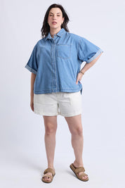 A model wearing the Annika Ss Denim Shirt in colour Midblue (Blue), from the front, showing the whole outfit