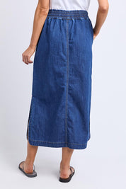 A model wearing the Clover Midi Denim Skirt in colour Midblue (Blue), from the back