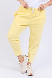 A model wearing the Fundamental Brunch Cotton Pant in colour Banana, from the front, cropped image