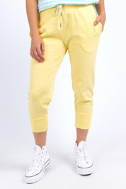 A model wearing the Fundamental Brunch Cotton Pant in colour Banana, from the front, cropped image