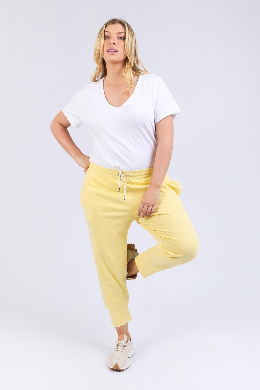 A model wearing the Fundamental Brunch Cotton Pant in colour Banana, from the front, showing the whole outfit