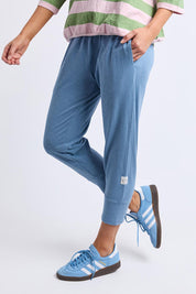 A model wearing the Fundamental Brunch Cotton Pant in colour Blueshadow (Blue), from the front, cropped image