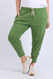 A model wearing the Fundamental Brunch Cotton Pant in colour Cedargreen (Green), from the front, cropped image