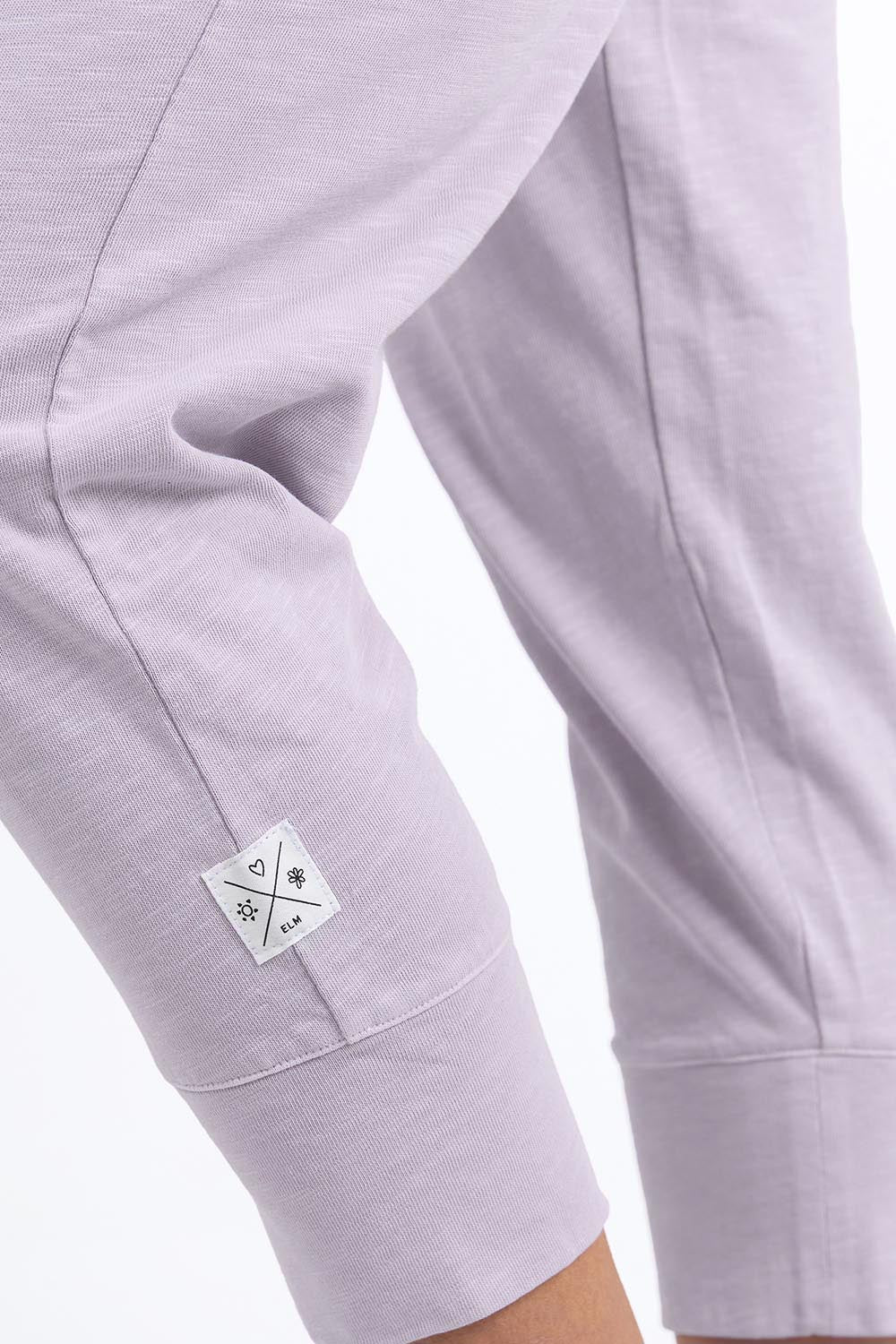 A model wearing the Fundamental Brunch Cotton Pant in colour Dustylilac (Purple), from the front, showing the whole outfit