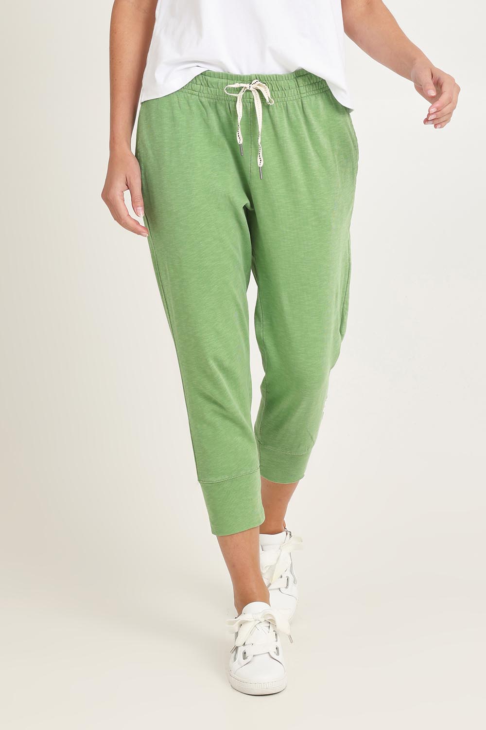 Model Madeline wearing size 10 of the Fundamental Brunch Cotton Pant in colour Forest (Green), from the front, cropped image
