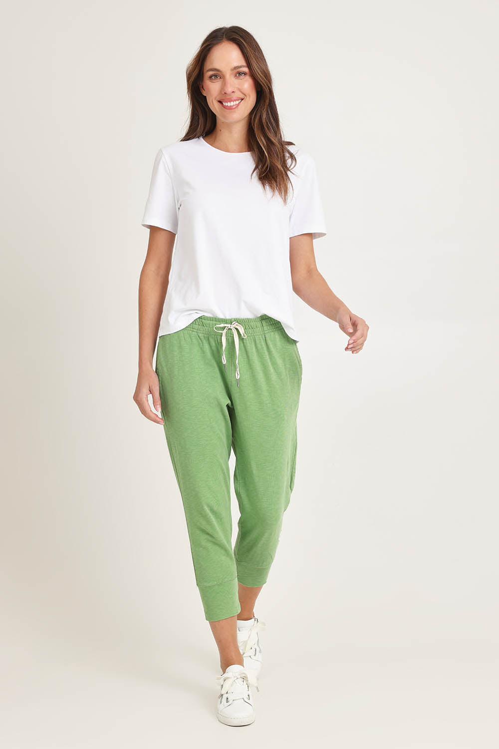 Model Madeline wearing size 10 of the Fundamental Brunch Cotton Pant in colour Forest (Green), from the front, showing the whole outfit