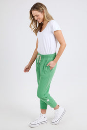 A model wearing the Fundamental Brunch Cotton Pant in colour Greenbriar (Green), from the front, showing the whole outfit