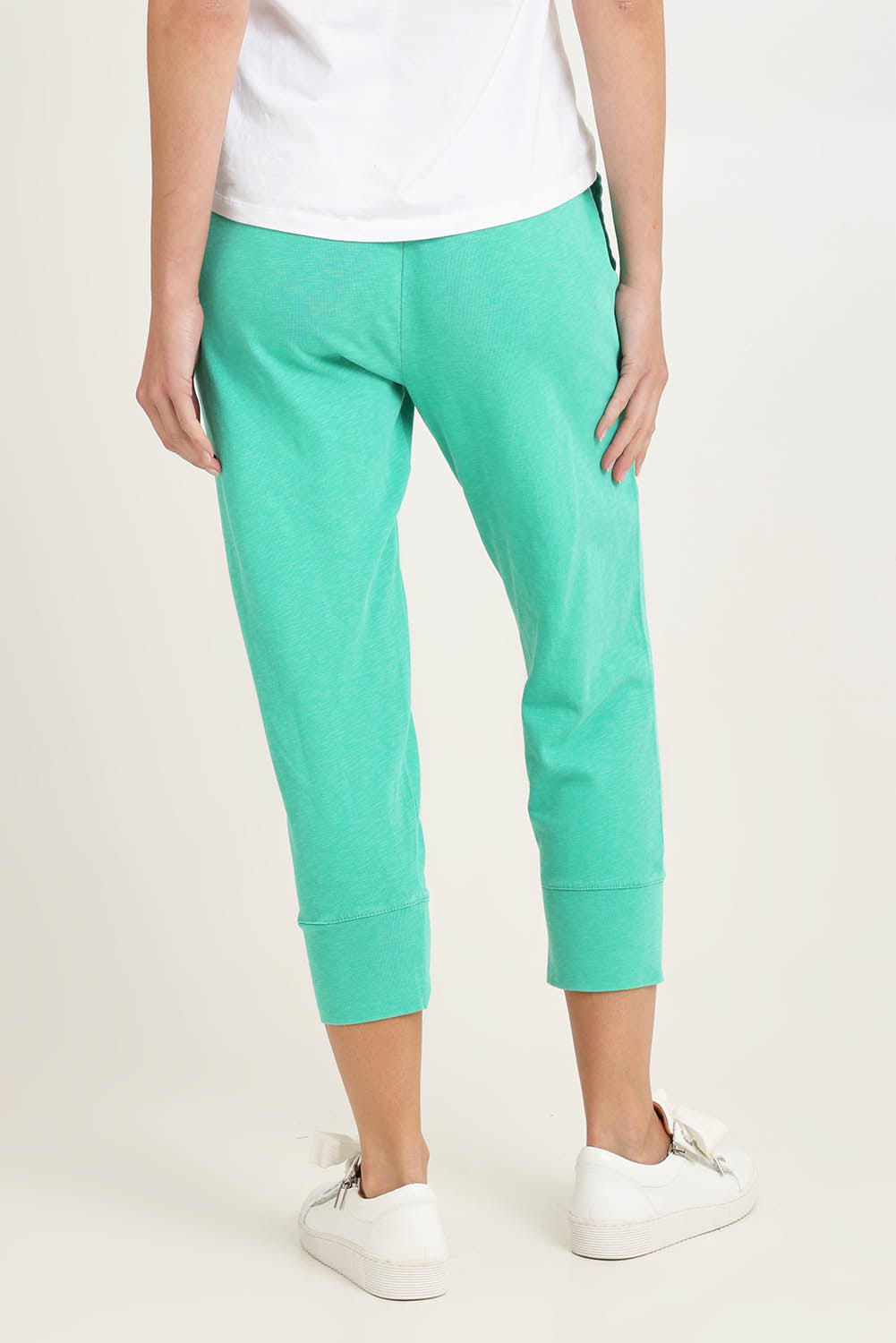 Model Madeline wearing size 10 of the Fundamental Brunch Cotton Pant in colour Gumdrop (Green), from the back