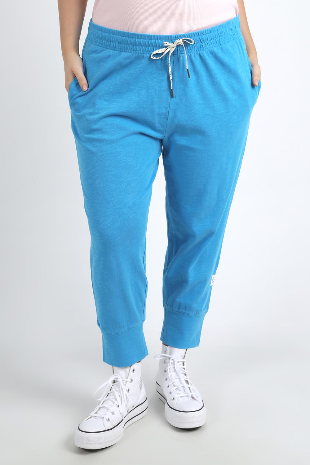 A model wearing the Fundamental Brunch Cotton Pant in colour Ibizablue (Blue), from the front, cropped image