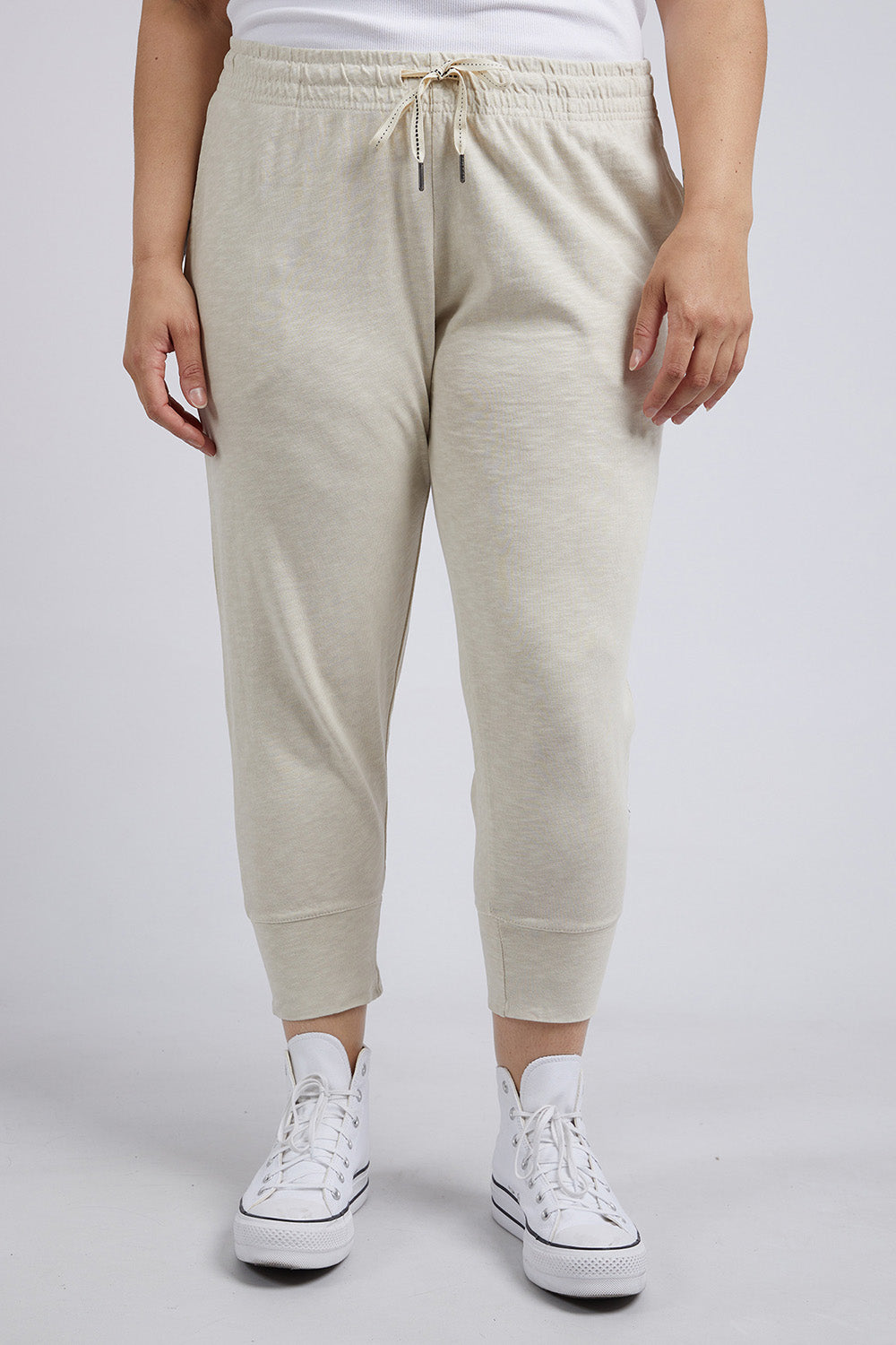 A model wearing the Fundamental Brunch Cotton Pant in colour Linen, from the front, cropped image