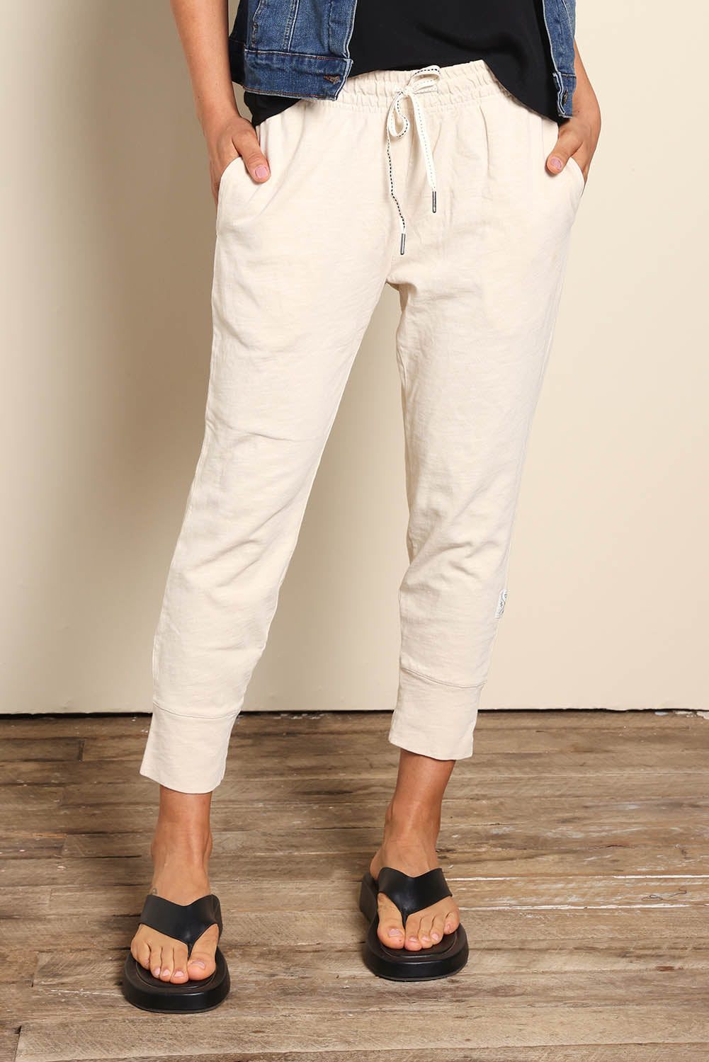 Model Pamelar wearing size 10 of the Fundamental Brunch Cotton Pant - Linen in colour Linen, in a cropped view