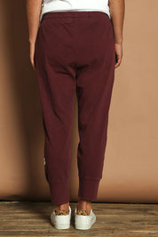 Model Katie wearing size 10 of the Fundamental Brunch Cotton Pant in colour Merlot (Red), from the back