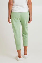 Model Madeline wearing size 10 of the Fundamental Brunch Cotton Pant in colour Quietgreen (Green), from the back