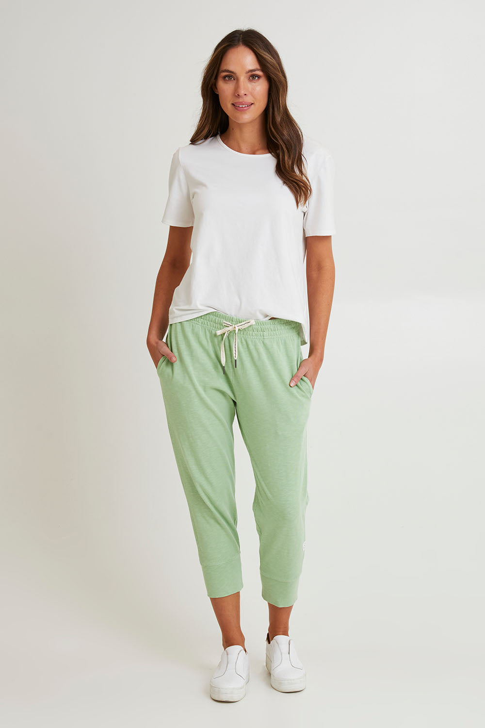Model Madeline wearing size 10 of the Fundamental Brunch Cotton Pant in colour Quietgreen (Green), from the front, showing the whole outfit
