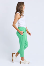A model wearing the Fundamental Brunch Cotton Pant in colour Springgree (Green), from the front, showing the whole outfit