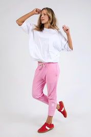 A model wearing the Fundamental Brunch Cotton Pant in colour Strawberry (Pink), from the front, showing the whole outfit