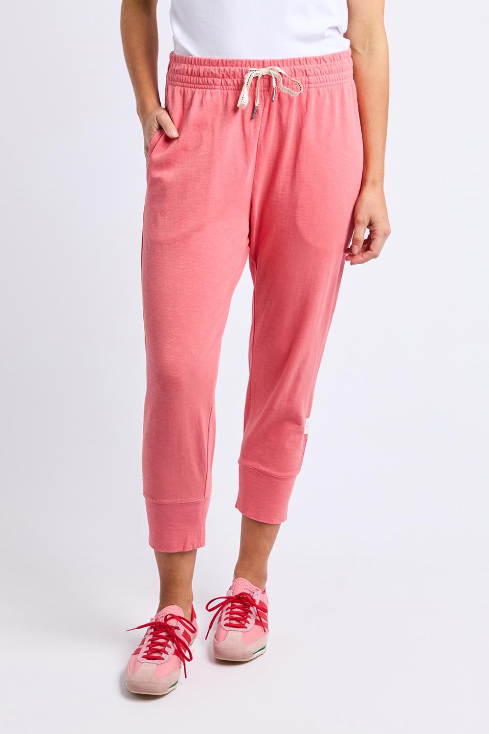 A model wearing the Fundamental Brunch Cotton Pant in colour Sugarcoral (Pink), from the front, cropped image
