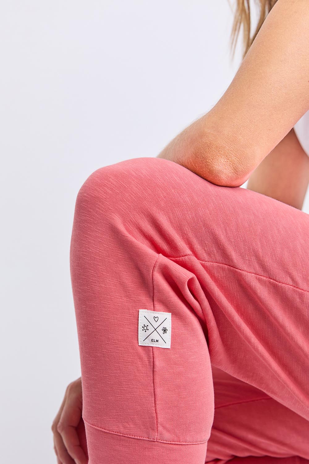 A model wearing the Fundamental Brunch Cotton Pant in colour Sugarcoral (Pink), from the front, cropped image