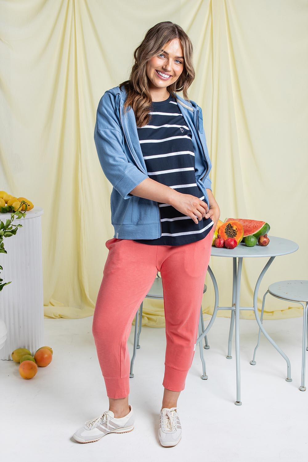A model wearing the Fundamental Brunch Cotton Pant in colour Sugarcoral (Pink), from the front, showing the whole outfit