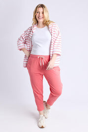 A model wearing the Fundamental Brunch Cotton Pant in colour Sugarcoral (Pink), from the front, showing the whole outfit