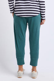 A model wearing the Fundamental Brunch Cotton Pant in colour Teal (Green), from the back