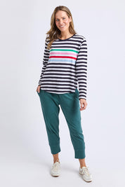A model wearing the Fundamental Brunch Cotton Pant in colour Teal (Green), from the front, showing the whole outfit