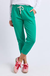 A model wearing the Fundamental Brunch Cotton Pant in colour Turquoise (Green), from the front, cropped image