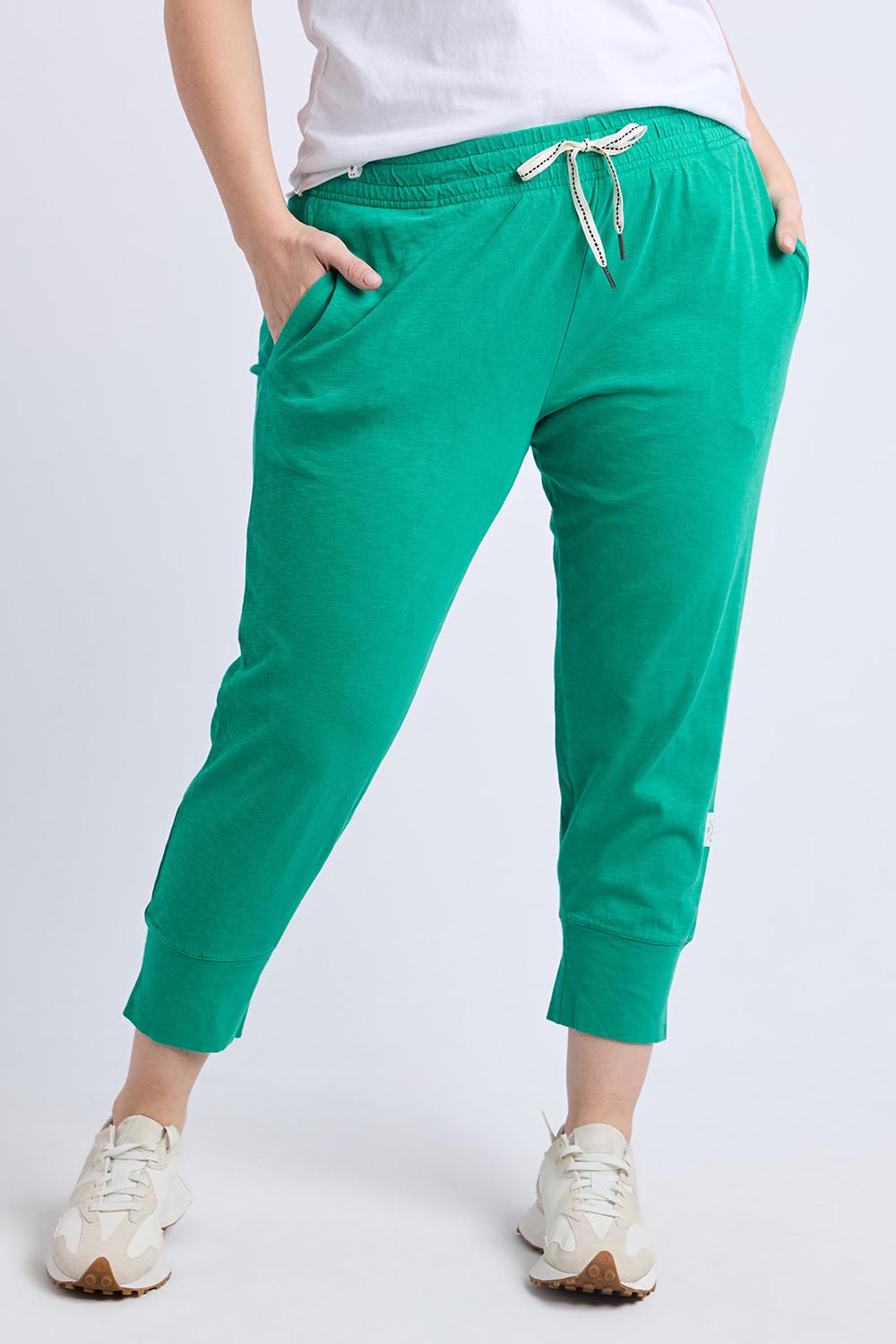 A model wearing the Fundamental Brunch Cotton Pant in colour Turquoise (Green), from the front, cropped image