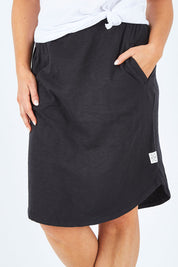 Model Shadae wearing size 10 of the Fundamental Isla Skirt in colour Black (Black), from the front, cropped image