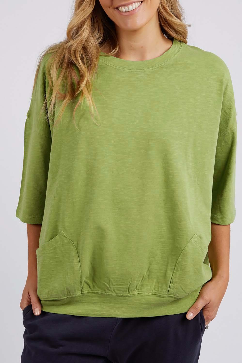 A model wearing the Fundamental Mazie Cotton Sweat Top in colour Junglegre (Green), from the front, cropped image