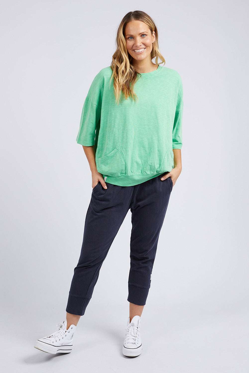 A model wearing the Fundamental Mazie Cotton Sweat Top in colour Meadow (Green), from the front, showing the whole outfit