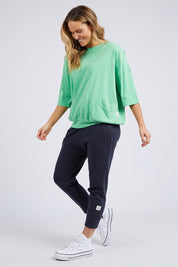 A model wearing the Fundamental Mazie Cotton Sweat Top in colour Meadow (Green), from the front, showing the whole outfit