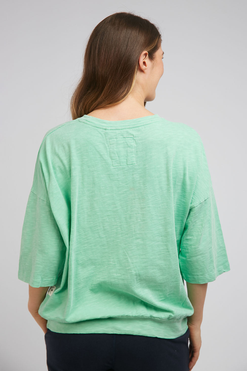 A model wearing the Fundamental Mazie Cotton Sweat Top in colour Mistymoss (Green), from the back