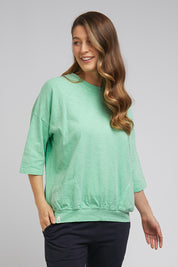 A model wearing the Fundamental Mazie Cotton Sweat Top in colour Mistymoss (Green), from the front, cropped image
