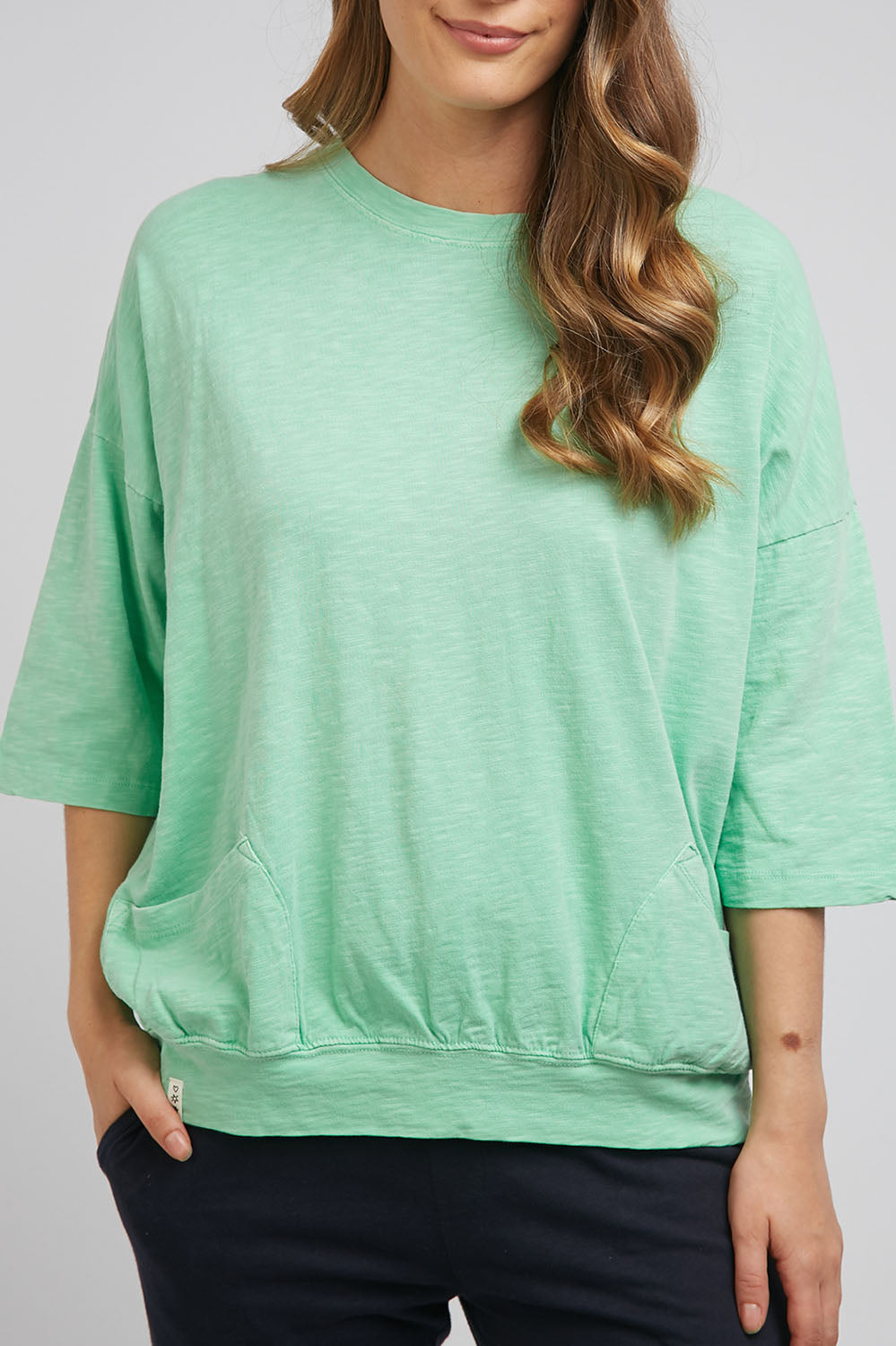 A model wearing the Fundamental Mazie Cotton Sweat Top in colour Mistymoss (Green), from the front, cropped image