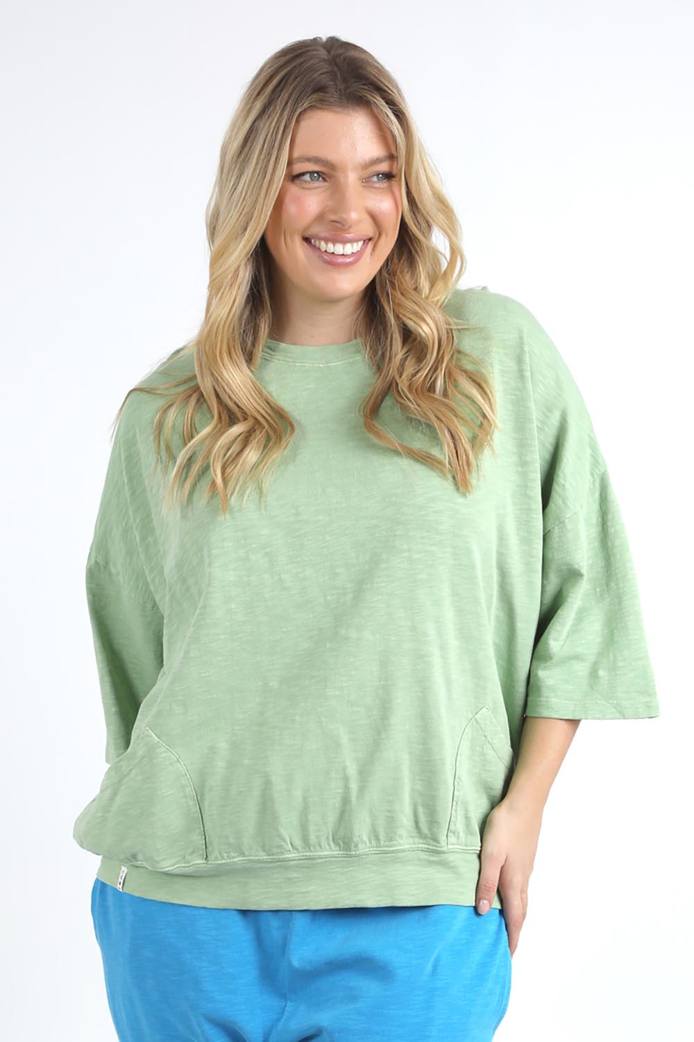 A model wearing the Fundamental Mazie Cotton Sweat Top in colour Quietgreen (Green), from the front, cropped image