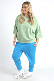A model wearing the Fundamental Mazie Cotton Sweat Top in colour Quietgreen (Green), from the front, showing the whole outfit