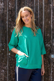 A model wearing the Fundamental Mazie Cotton Sweat Top in colour Turquoise (Green), from the front, showing the whole outfit