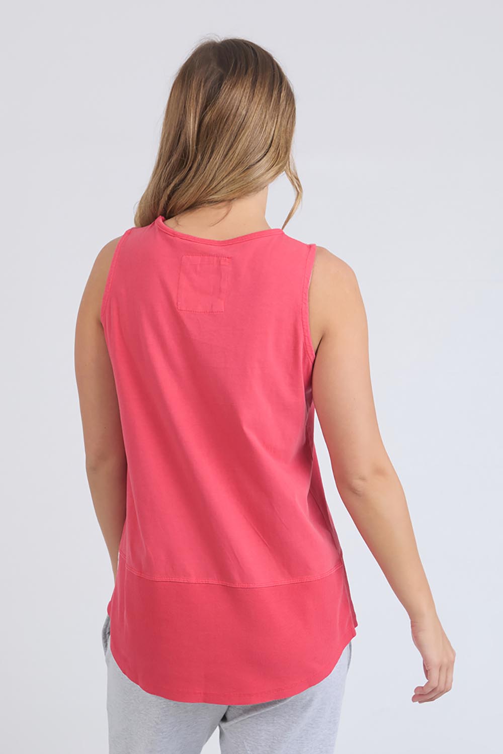 A model wearing the Fundamental Rib Cotton Tank in colour Bitterred (Red), from the back