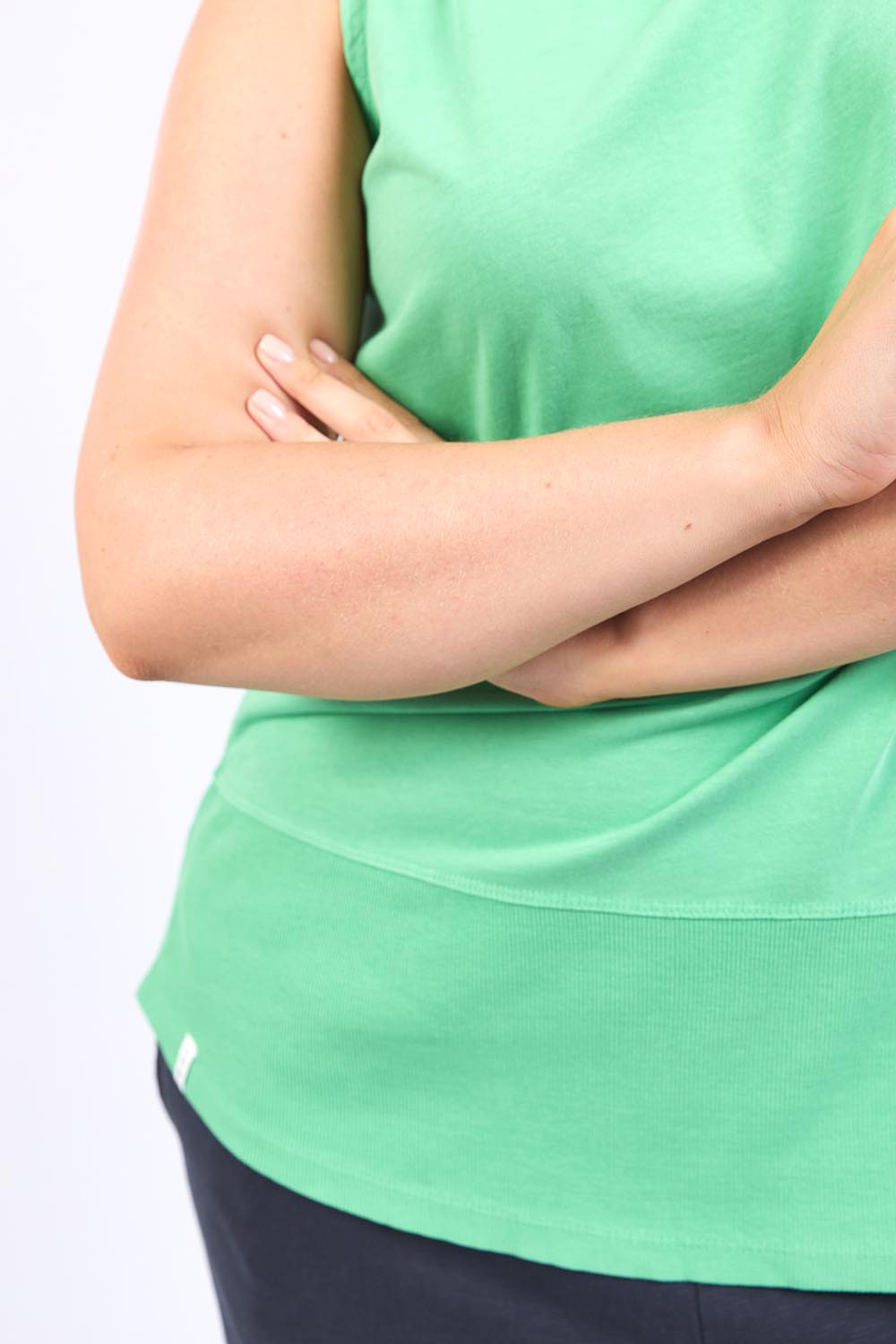A model wearing the Fundamental Rib Cotton Tank in colour Greenbriar (Green), from the front, cropped image