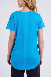 A model wearing the Fundamental Vee Cotton Tee in colour Ibizablue (Blue), from the back